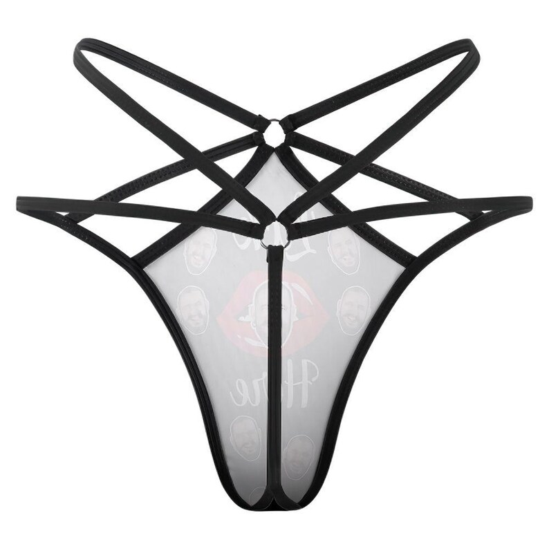 Puede incluir: Lencer&iacute;a negra con un dise&ntilde;o &uacute;nico. La prenda presenta una tela blanca transparente con un patr&oacute;n de caras y un gr&aacute;fico de labios rojos. Las correas negras crean un patr&oacute;n en forma de estrella.