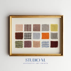 Pode incluir: Uma impressão artística emoldurada apresentando uma grade de quinze amostras de tecido quadradas em várias cores e padrões, incluindo xadrez, tweed e texturas sólidas. A moldura é dourada e o texto STUDIO M. AESTHETIC ART PRINTS aparece abaixo.