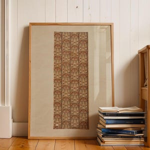 May include: A framed rectangular print featuring a repeating pattern of brown and beige gothic-style arched windows. The artwork is encased in a light-colored wooden frame and is positioned vertically against a white paneled wall.