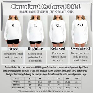以下が含まれることがあります： 白の Comfort Colors ヘビーウェイト長袖Tシャツ、サイズはM、L、XL、2XL。画像には、幅、長さ、袖丈（cm）などのサイズ情報が記載されています。シャツは100％リングスパンコットン製です。
