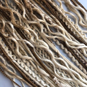 May include: A collection of brown and white synthetic dreadlocks. The dreadlocks are made of a soft, textured yarn and are ready to be added to your hair.