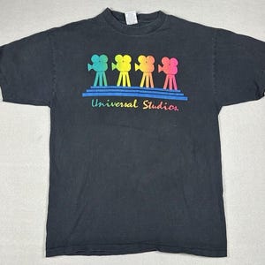 May include: Black short-sleeved t-shirt with a graphic of four rainbow-colored film cameras and the text "Universal Studios".