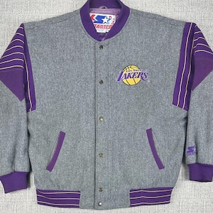 May include: Gray Los Angeles Lakers Starter jacket with purple and gold accents. Features the Lakers logo on the chest, purple sleeves, and a purple collar. The jacket has a button-up front and two front pockets.