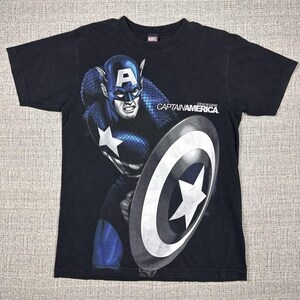 May include: Black t-shirt featuring Captain America with his shield. The graphic shows Captain America in his blue and white costume, holding his shield. The text "CAPTAIN AMERICA" is printed on the shirt.