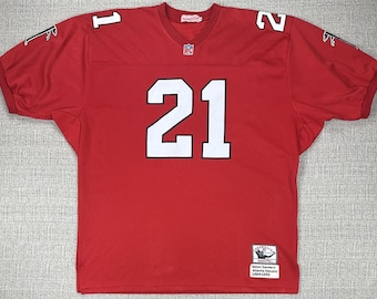 May include: A red football jersey with white numbers and lettering. The jersey features the number 21 prominently on the front and the number 1 and 2 on the shoulders. The jersey has the NFL logo and a tag that reads "Deion Sanders Atlanta Falcons 1989-1993."