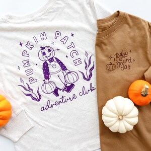 Peut inclure: Deux chemises à manches longues, une grise claire et une marron, avec des graphiques sur le thème de l'automne. La chemise gris clair présente un motif de champ de citrouilles violet. La chemise marron a une citrouille et le texte "today is a gourd day".