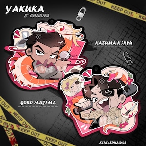 May include: Two 3-inch acrylic charms featuring cartoon illustrations of Kazuma Kiryu and Goro Majima. Kiryu is depicted with a dragon, while Majima is shown with a snake, both holding microphones. The text YAKUKA 3" CHARMS, KAZUMA KIRYU, and GORO MAJIMA is visible.
