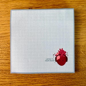 May include: A light blue card with a grid pattern. The card has a red heart with headphones on and musical notes around it. The text "Listen to your heart" is below the heart.