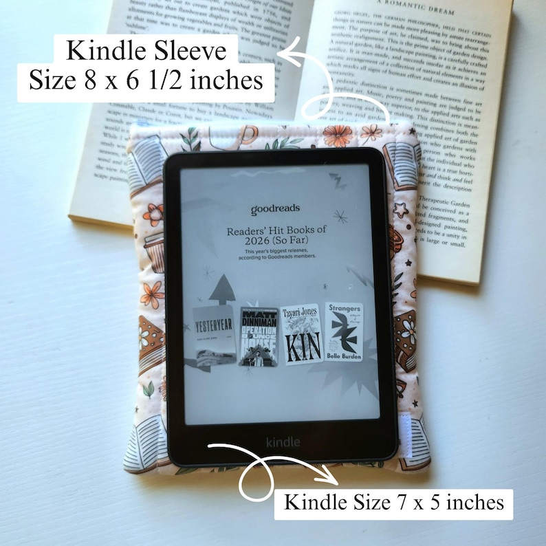 May include: A padded fabric Kindle sleeve featuring a pattern of books and flowers, measuring 8 by 6.5 inches. A black Kindle e-reader measuring 7 by 5 inches is placed on top of the sleeve, displaying a Goodreads screen with book covers.