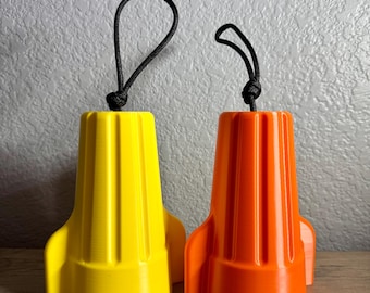 May include: Two plastic rocket-shaped bottle stoppers, one yellow and one orange, with black rope handles.