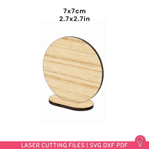 Könnte beinhalten: Ein runder Holzständer mit schwarzem Rand, 7 x 7 cm groß. Der Ständer hat einen kleinen, rechteckigen Sockel. Der Text "7x7cm 2.7x2.7in" steht oben. Der untere Teil des Bildes lautet "LASER CUTTING FILES | SVG DXF PDF".