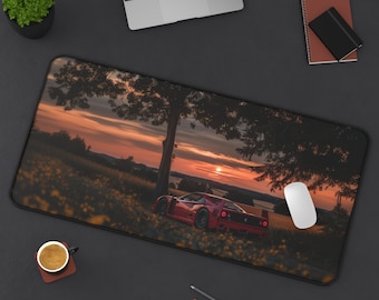 Può includere: Una Ferrari sportiva rossa parcheggiata su un campo erboso con un tramonto sullo sfondo. L'auto è rivolta verso il lato destro dell'immagine. L'auto è circondata da erba verde e alberi. Il cielo è di un arancione e rosa vibrante.