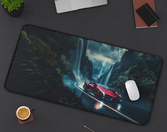 Può includere: Un tappetino per mouse da gioco nero e rosso con una scena di foresta oscura e un'auto sportiva rossa che guida attraverso una cascata. Il tappetino per mouse è su una superficie nera con un laptop, una tazza di caffè e matite.