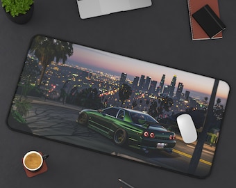 May include: A green sports car driving on a city street at night. The car is driving up a hill with a cityscape in the background. The street is lit with streetlights and the city lights are visible in the distance.