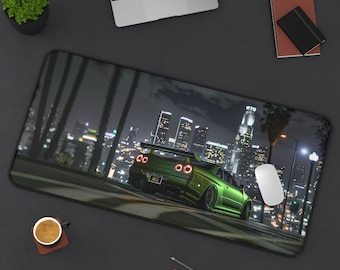 May include: A green Nissan Skyline GT-R sports car driving through a city at night. The car has a black spoiler and black wheels. The city skyline is visible in the background.