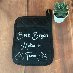 May include: Black quilted oven mitt with white text that reads "Best Biryani Maker in Town" and two white illustrations of bowls of biryani with chicken legs.