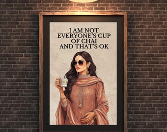 May include: Framed art print with the text "I AM NOT EVERYONE'S CUP OF CHAI AND THAT'S OK". The image shows a woman in sunglasses holding a cup of chai. She is wearing a peach-colored outfit. The print is in a wooden frame.