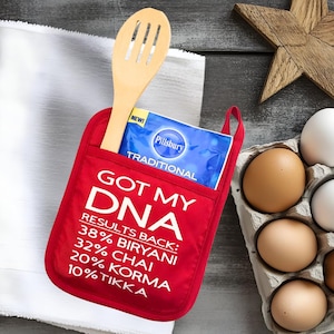 May include: Red oven mitt with a pocket and the text "Got My DNA Results Back: 38% Biryani, 32% Chai, 20% Korma, 10% Tikka".