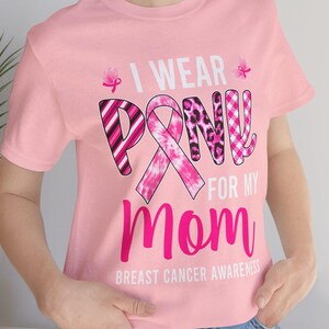 May include: Pink t-shirt with a pink ribbon design and the text "I wear pink for my mom Breast Cancer Awareness".
