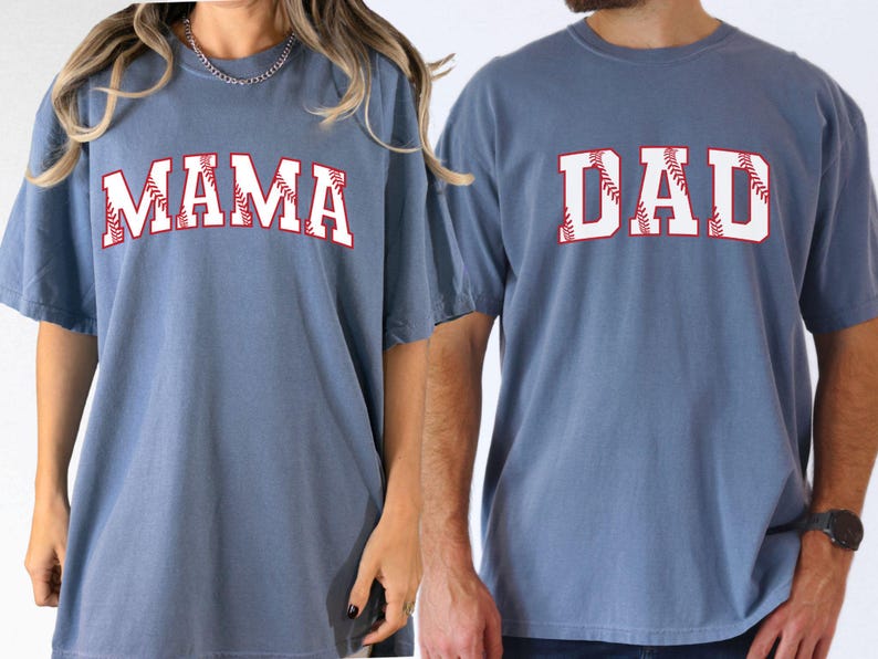 May include: Two blue t-shirts with white text and red baseball stitching. The text on the left shirt says "MAMA" and the text on the right shirt says "DAD".