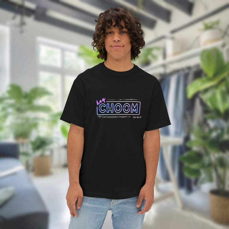 A man inside of a bedroom wearing a black Cyberpunk 2077 Hey Choom Unisex Oversized T-Shirt by New Save.