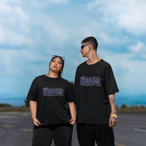 A couple wearing matching black Cyberpunk 2077 Hey Choom Unisex Oversized T-Shirts by New Save.