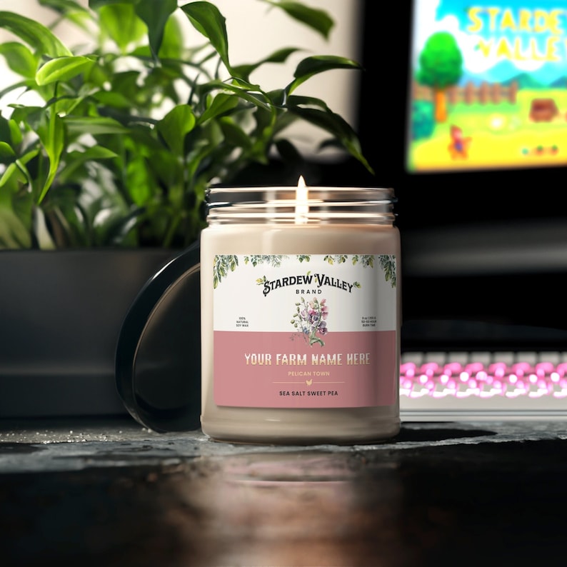 Soy candle in a glass vessel with a label design inspired by the game Stardew Valley. The label has graphics to match the scent along with text that says Stardew Valley, Pelican Town and customizable text for a Farm Name.