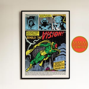 May include: Framed comic book art featuring a panel from The Vision. The artwork shows a green and yellow superhero flying over a city, with the text "BEHOLD... THE VISION!" The piece is framed in black and includes the "MMM COMICS" logo.