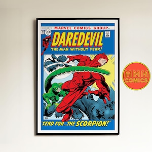 Puede incluir: Portada de cómic vintage enmarcada con Daredevil con un traje rojo, luchando contra un villano verde. La portada tiene un fondo azul con el texto "DAREDEVIL" y "THE MAN WITHOUT FEAR!". El cómic es de Marvel Comics.