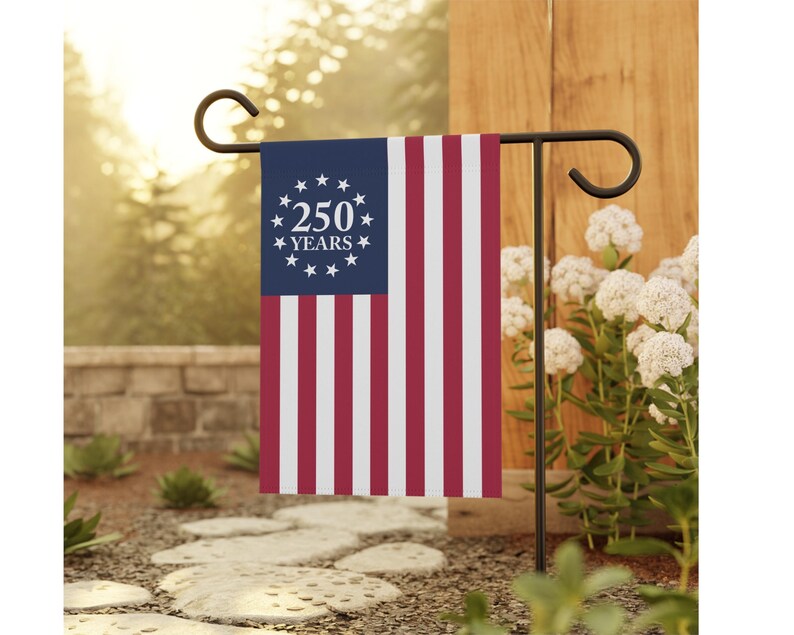 May include: A rectangular garden flag featuring a blue canton with a circle of thirteen white stars surrounding the white text 250 YEARS. The flag has vertical red and white stripes and is displayed on a black metal garden flag stand.