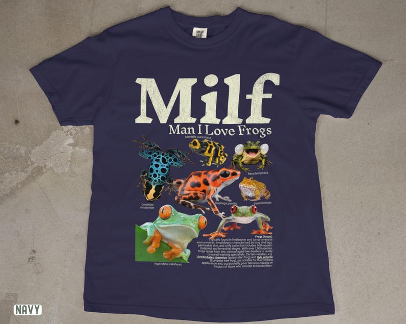 May include: Navy blue t-shirt featuring the text "Milf Man I Love Frogs" in white, with various colorful frog illustrations. The shirt includes scientific names and descriptions of the frogs.