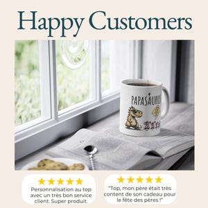 Puede incluir: Taza de cer&aacute;mica blanca con la palabra "PAPASAURUS" y un dinosaurio de dibujos animados con gafas de sol. La taza est&aacute; sobre un libro abierto cerca de una ventana. Tambi&eacute;n aparece el texto "Happy Customers".