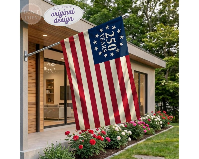 May include: A rectangular flag featuring thirteen alternating red and off-white horizontal stripes. The blue canton displays a circular arrangement of thirteen white stars surrounding the text 250 YEARS in a bold, white, serif font.