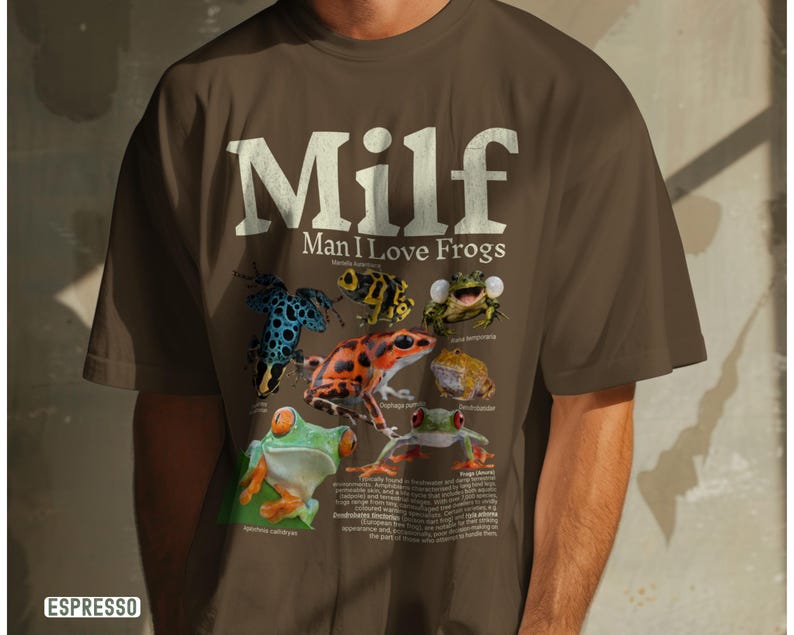 May include: Espresso-colored t-shirt with the text "Milf Man I Love Frogs" in white. The shirt features colorful illustrations of various frog species. The word "Espresso" is printed in a white rectangle at the bottom left.