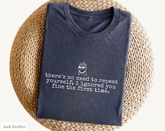 May include: Dark heather t-shirt with a crew neck, featuring a white graphic of a cat wearing sunglasses and a party hat, and the text "there's no need to repeat yourself, i ignored you fine the first time."