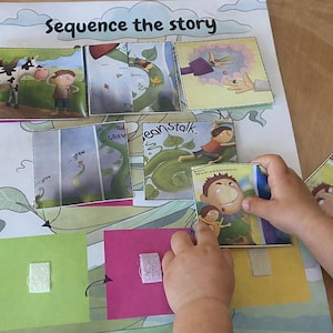 May include: A children's educational game titled "Sequence the Story" featuring illustrations from the story of Jack and the Beanstalk. The game includes illustrated cards and a zebra cutout. A child's hands are interacting with the game.