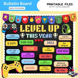 May include: A digital bulletin board design featuring a black background with pixel art elements including game controllers, a headset, and banners. The text reads LEVEL UP THIS YEAR along with motivational phrases like BE HAPPY, SHINE, and AIM HIGH.