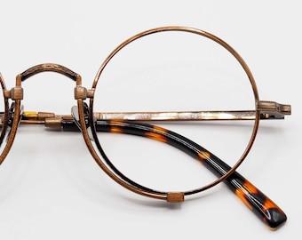 Monturas de gafas redondas vintage de titanio con diseño de carey.