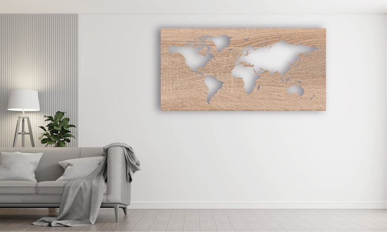 May include: A light wood wall decor with a cutout of the world map. The map is in a light brown color and the background is a light wood color. The decor is hanging on a white wall in a living room setting.