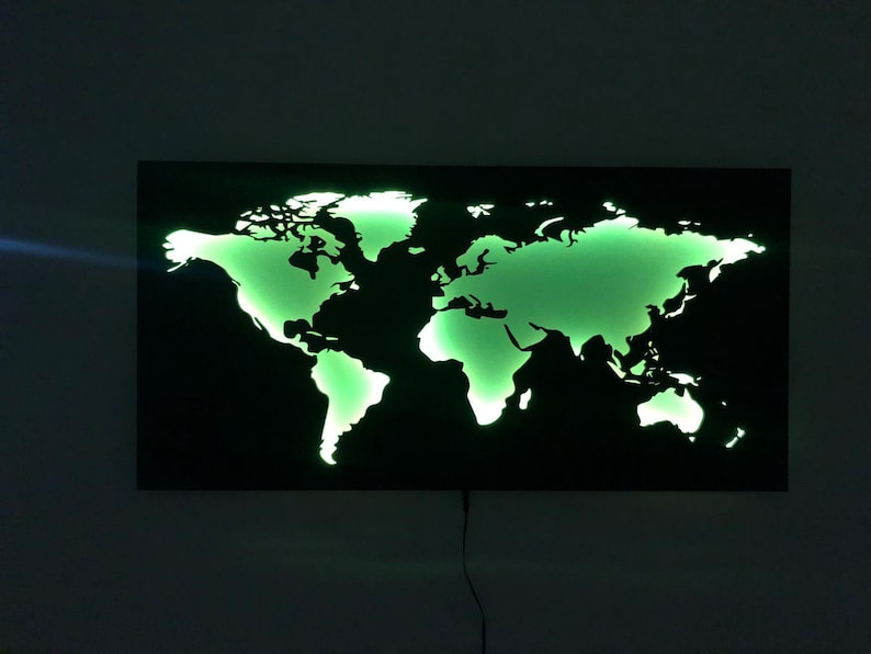 May include: A black metal world map wall decor with a green light shining through the cut-out continents.