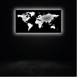 May include: A black world map with white continents is illuminated by a white light behind it. The map is mounted on a black wall.