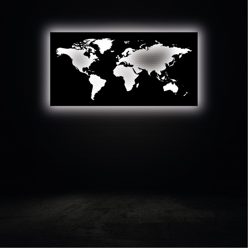 May include: A black world map with white continents is illuminated by a white light behind it. The map is mounted on a black wall.