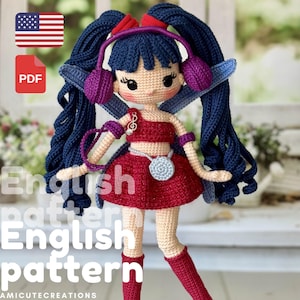 May include: A handmade crochet doll with blue hair, wearing a red outfit and purple headphones. The doll has a silver necklace and red boots. The image includes a PDF icon and a US flag icon.