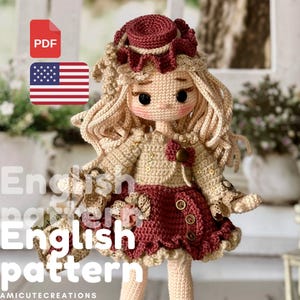 May include: A handcrafted crochet doll in a burgundy and beige outfit, complete with a matching hat and long blonde hair. The doll features large black eyes and decorative details. The image includes the text "English pattern" and a PDF icon with the American flag.