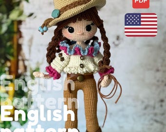 May include: A crocheted doll dressed as a cowgirl, wearing a tan cowboy hat with a turquoise accent, a white shirt with pink and blue trim, and brown pants. The doll holds a rope and has long brown braids. The image includes the text "English pattern".