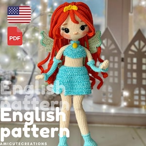 以下が含まれることがあります： 赤い髪、青い衣装、緑の羽を持つ手作りのかぎ針編み人形。人形は黄色の王冠と笑顔の顔をしています。画像には「English pattern」というテキストが含まれています。