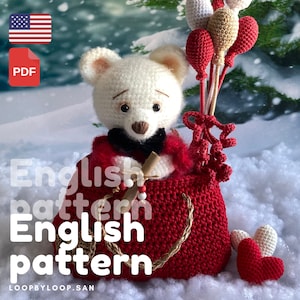 May include: A white crocheted teddy bear wearing a red sweater and a black bow tie is holding a stick and sitting in a red crocheted bag. The bag has a brown rope handle and is surrounded by white crocheted hearts and red and white crocheted balloons. The background is a snowy winter scene.