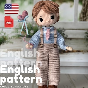 May include: A handmade crochet doll with brown hair, wearing a light blue shirt, tan overalls, and brown shoes. The doll holds a pink heart-shaped balloon. The image includes the text "English pattern" and a PDF icon.