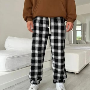May include: Black and white checkered pants with a drawstring waist. The pants are made of a soft, comfortable fabric and have a relaxed fit.