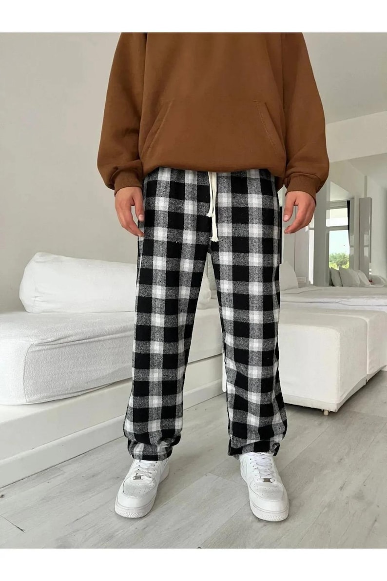 May include: Black and white checkered pants with a drawstring waist. The pants are made of a soft, comfortable fabric and have a relaxed fit.